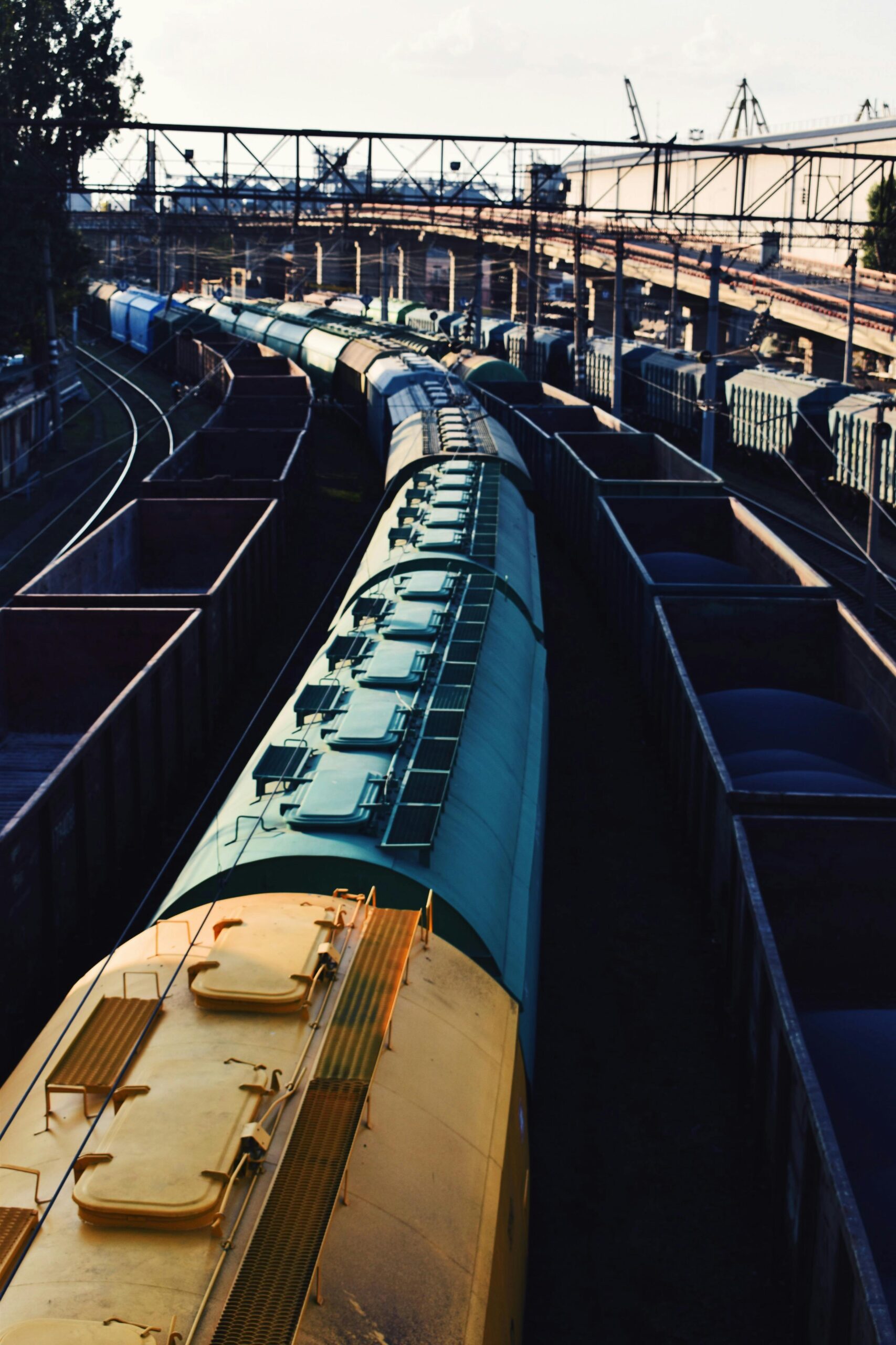 High angle view of freight trains at an industrial railway station with tracks and cargo containers.